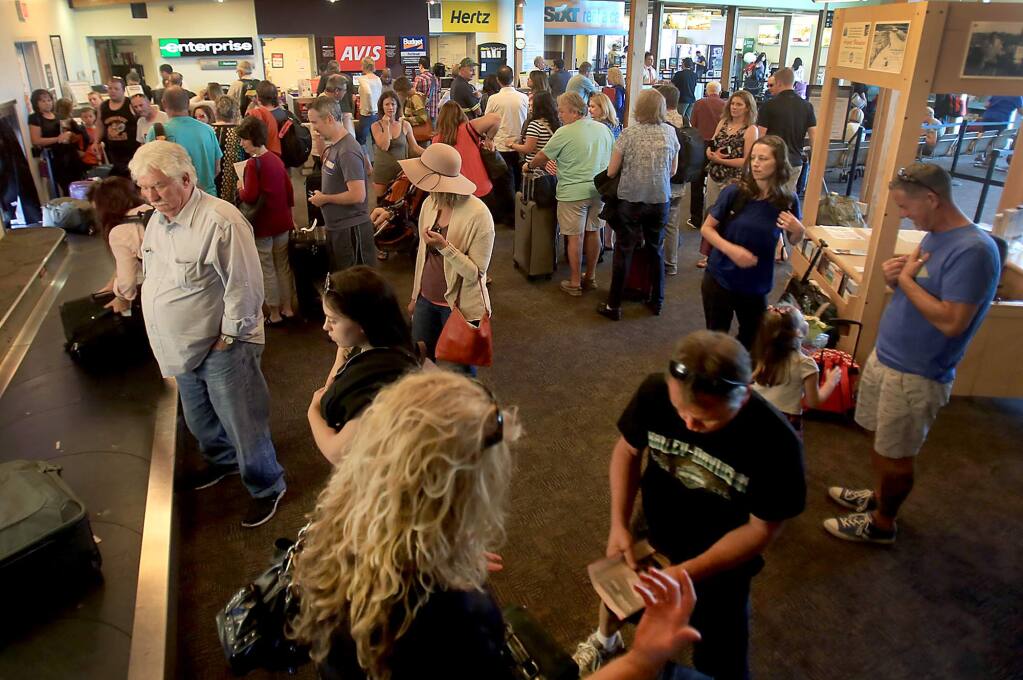 After an Allegiant Air flight deplaned, the terminal at the Charles M. Schulz Sonoma County Airport is jammed with passengers waiting for luggage and those in line for rental cars, Thursday Sept. 15, 2016 in Santa Rosa. (Kent Porter / The Press Democrat) 2016