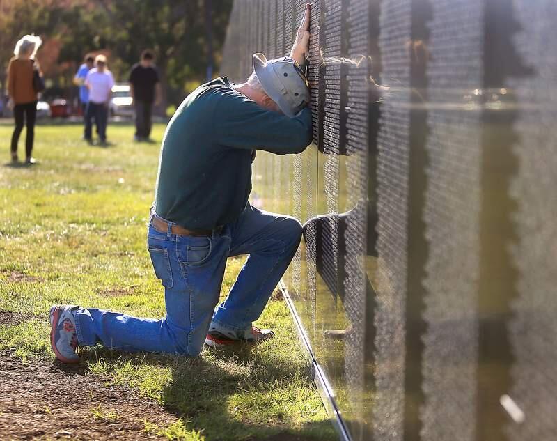 Stephen Brown of Cotati is overcome by grief as he spots friends that were killed during the Vietnam War. Brown was a helicopter pilot with the First Cavalry Division from 1969-70. Brown and hundreds of others visited the American Veterans Traveling Tribute Vietnam War memorial wall in Petaluma, Friday Oct. 11, 2013. Kent Porter / Press Democrat) 2013