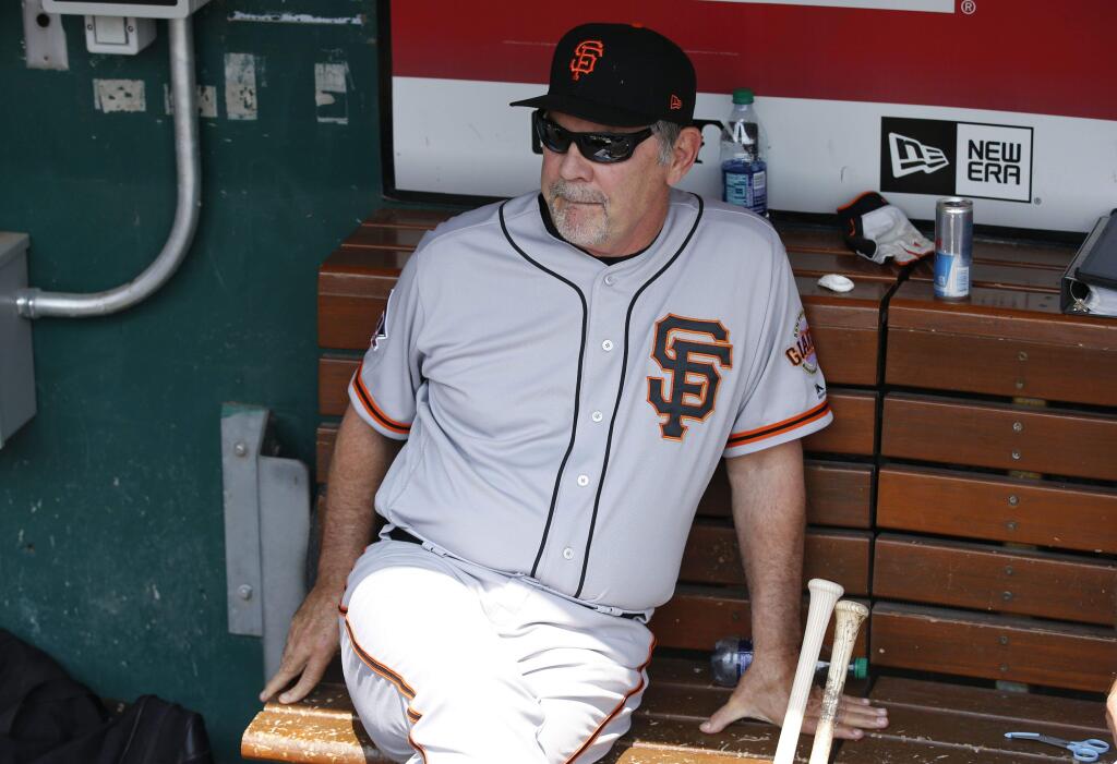 San Francisco Giants manager Bruce Bochy sits in the dugout before the start of a game against the Cincinnati Reds, Sunday, Aug. 19, 2018, in Cincinnati. (AP Photo/Gary Landers)