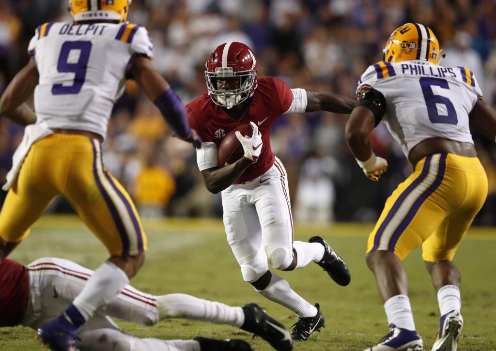 Alabama wide receiver Jerry Jeudy (4) carries against LSU safety Grant Delpit (9) and linebacker Jacob Phillips (6) on a pass play in the first half of an NCAA college football game in Baton Rouge, La., Saturday, Nov. 3, 2018. (AP Photo/Gerald Herbert)
