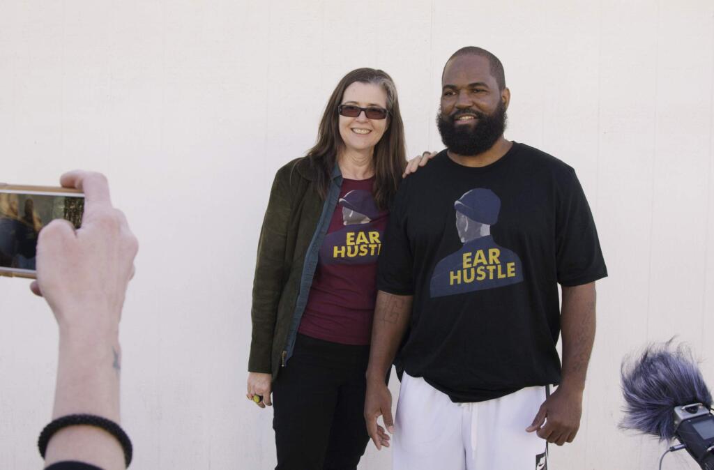 In this Nov. 30, 2018, photo provided by PRX, Nigel Poor, left, and Earlonne Woods, podcast co-hosts and co-producers for 'Ear Hustle,' stand outside San Quentin State Prison on Woods' release day in San Quentin, Calif. Woods, 47, was released from the prison after California Gov. Jerry Brown commuted his 31-years-to-life sentence for attempted armed robbery. Brown cited Woods' leadership in helping other inmates and his work at “Ear Hustle,” a podcast he co-hosts and co-produces that documents everyday life inside the prison. (Kesten Migdal/PRX via AP)