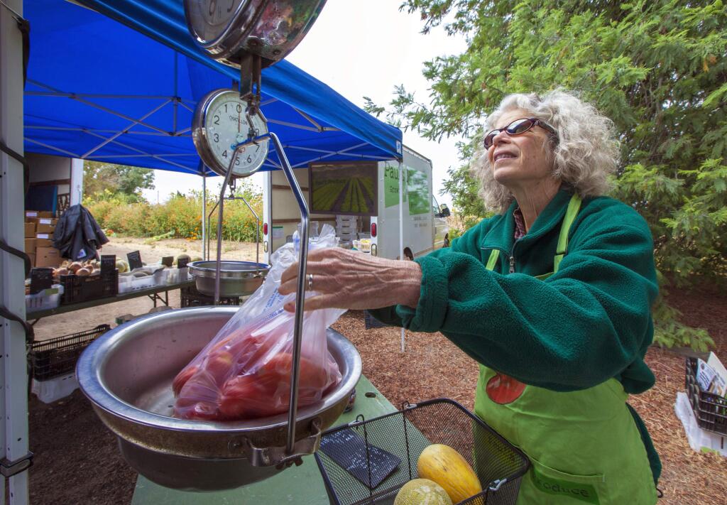 Candi Edmondson, sales manager for Paul's Produce, working the Arnold Drive farm stand on Saturday morning. Paul's Produce also sells organic vegetables at the Tuesday and Friday farmers markets in Sonoma. (Photo by Robbi Pengelly/Index-Tribune)