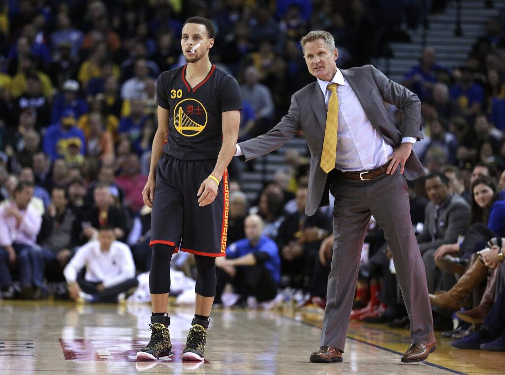Golden State Warriors coach Steve Kerr pats Stephen Curry on the back as Curry re-enters the Warriors' NBA basketball game against the Milwaukee Bucks during the second half Wednesday, March 4, 2015, in Oakland, Calif. (AP Photo/Ben Margot)