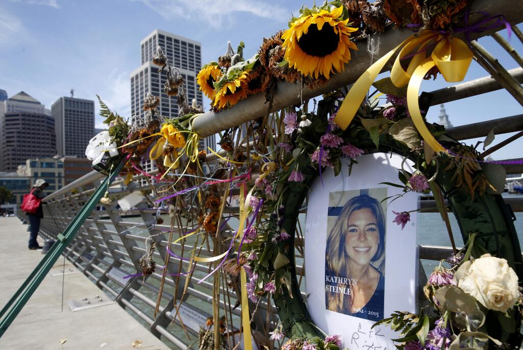 FILE - In this July 17, 2015 file photo, flowers and a portrait of Kate Steinle remain at a memorial site on Pier 14 in San Francisco. (Paul Chinn/San Francisco Chronicle via AP, File)