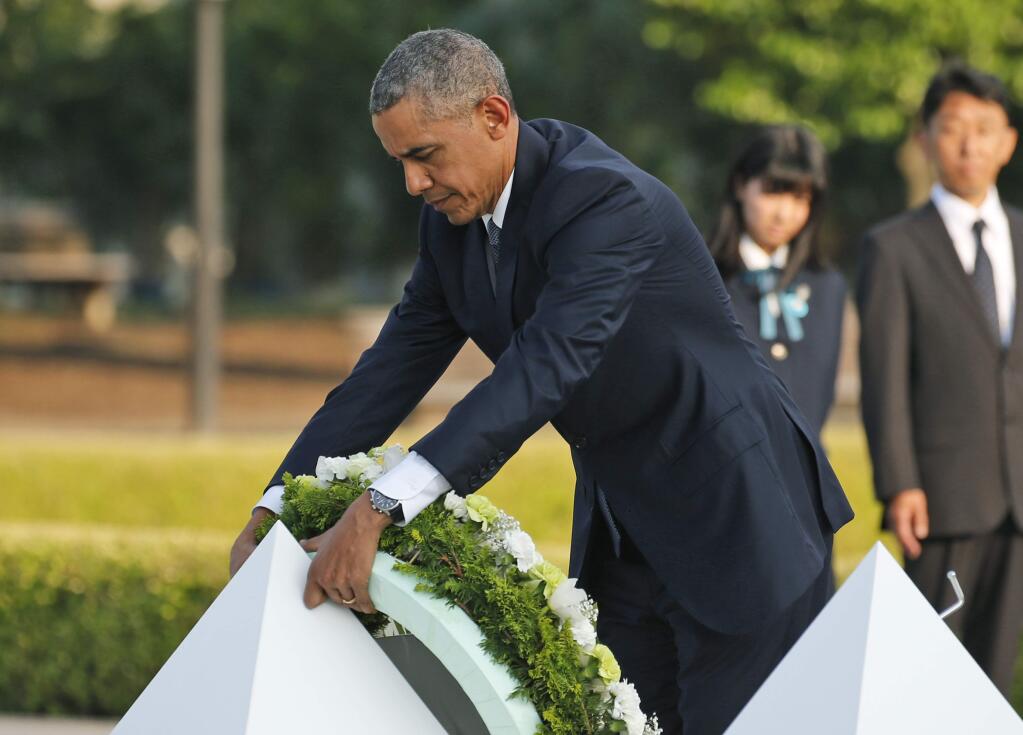 U.S. President Barack Obama lays wreaths at the cenotaph at Hiroshima Peace Memorial Park in Hiroshima, western Japan, Friday, May 27, 2016. Obama on Friday became the first sitting U.S. president to visit the site of the world's first atomic bomb attack, bringing global attention both to survivors and to his unfulfilled vision of a world without nuclear weapons. (AP Photo/Shuji Kajiyama)