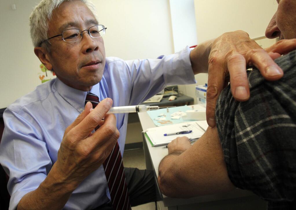 Dr. Harry Chen gives a whooping cough vaccine at a clinic in Barre, Vt. (TOBY TALBOT/ AP)