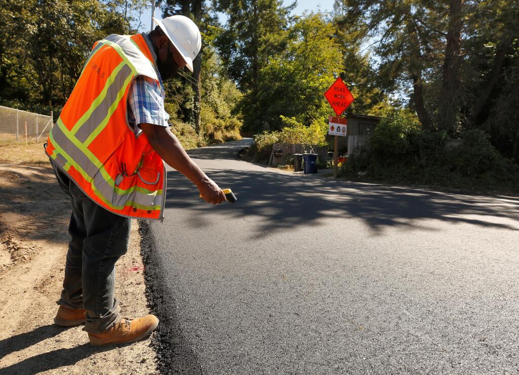 Project inspector Ibrahim Mcharo of Psomas Engineering takes a temperature reading of the freshly laid asphalt from the repaving work on Barnett Valley Road near Bodega Highway in Sebastopol, California, on Wednesday, July 29, 2020. Sonoma County Supervisors on May 25 approved a new round of Pavement Preservation Program projects, which, when combined with PG&E settlement funding will funnel more than $10 million to projects adjacent to Petaluma. (Alvin Jornada / The Press Democrat)