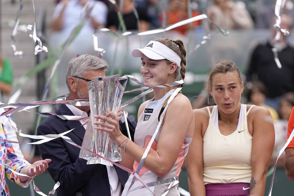 Elena Rybakina, of Kazakhstan, middle, celebrates after defeating Aryna Sabalenka, of Belarus, right, in the women's singles final at the BNP Paribas Open tennis tournament Sunday, March 19, 2023, in Indian Wells, Calif. (AP Photo/Mark J. Terrill)