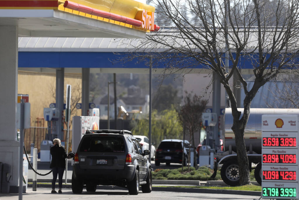A woman fills her vehicle with gas at the Shell station located across the street from a Chevron gas station at Lakeville Street and Caulfield Lane in Petaluma on Thursday, March 4, 2021. The Petaluma City Council on March 1 voted to ban new gas station construction, and other agencies are now exploring the same step. (BETH SCHLANKER/THE PRESS DEMOCRAT)