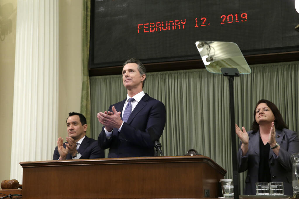 FILE - California Gov. Gavin Newsom, flanked by Assembly Speaker Anthony Rendon, left, and Senate President Pro Tempore Toni Atkins, right, applaud as introductions are made during Newsom's first State of the State address at the Capitol, on, Feb. 12, 2019, in Sacramento, Calif. California’s budget surplus has soared to a record $68 billion, Senate Democrats said Thursday, April 28, 2022, fueling a range of new spending proposals that include giving $8 billion back to taxpayers in the form of $200 checks.  (AP Photo/Rich Pedroncelli, File)