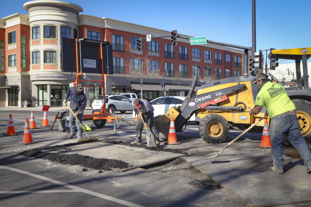 A crew works on patching up the road at Petaluma Boulevard and D Street Tuesday, Jan. 19, 2021. (CRISSY PASCUAL/ARGUS-COURIER STAFF)
