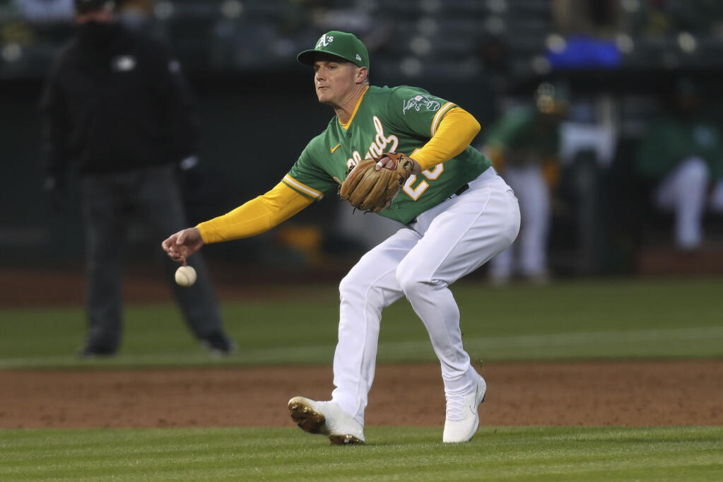 Oakland Athletics third baseman Matt Chapman can’t field a single hit by the Los Angeles Dodgers’ Austin Barnes during the fourth inning in Oakland on Tuesday, April 6, 2021. (Jed Jacobsohn / ASSOCIATED PRESS)