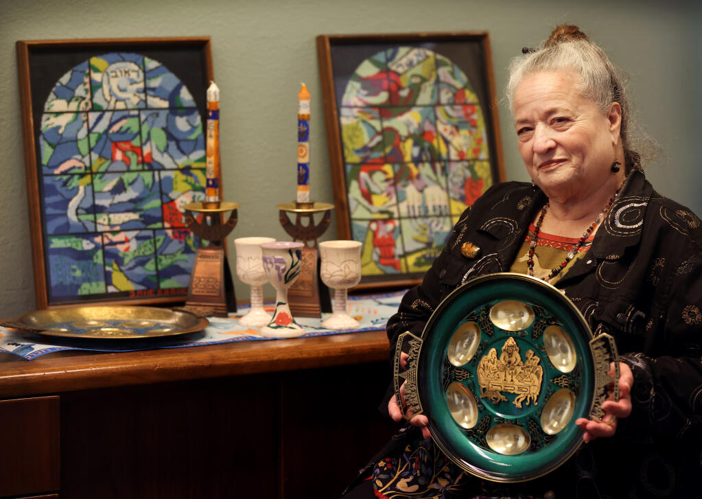 Sandy Andresen, director of the Friendship Circle Program at the Jewish Community Center of Sonoma County, hold a traditional Passover seder plate. Photo taken at the center in Santa Rosa, Wednesday, March 29, 2023. (Beth Schlanker/The Press Democrat)