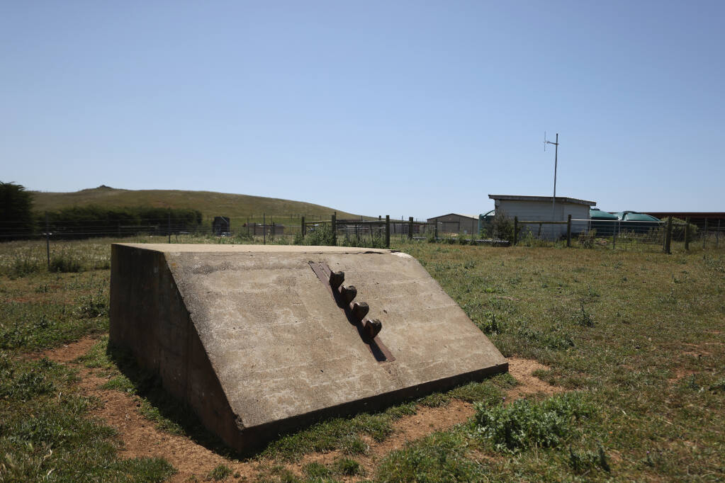 A concrete anchor once used for an American Marconi Company radio tower is still found on the Barinaga Ranch property in Marshall. Behind it, a storage shed houses an antenna and KDAN FM radio station repeating equipment. Photo taken in Marshall, Calif., on Tuesday, May 17, 2022. (Beth Schlanker/The Press Democrat)