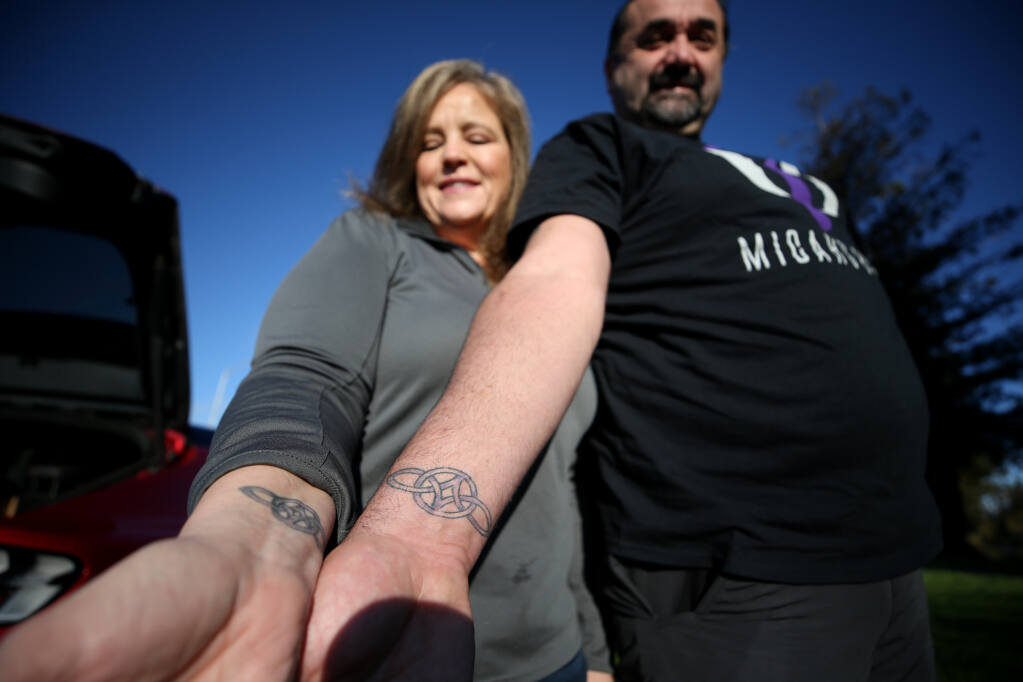 Michelle and Micah Sawyer, founders of the new nonprofit Micah’s Hugs, have matching tattoos containing the ashes of Micah Sawyer Jr. Photo taken in Rohnert Park, Calif., on Tuesday, Dec. 14, 2021. (Beth Schlanker/The Press Democrat)