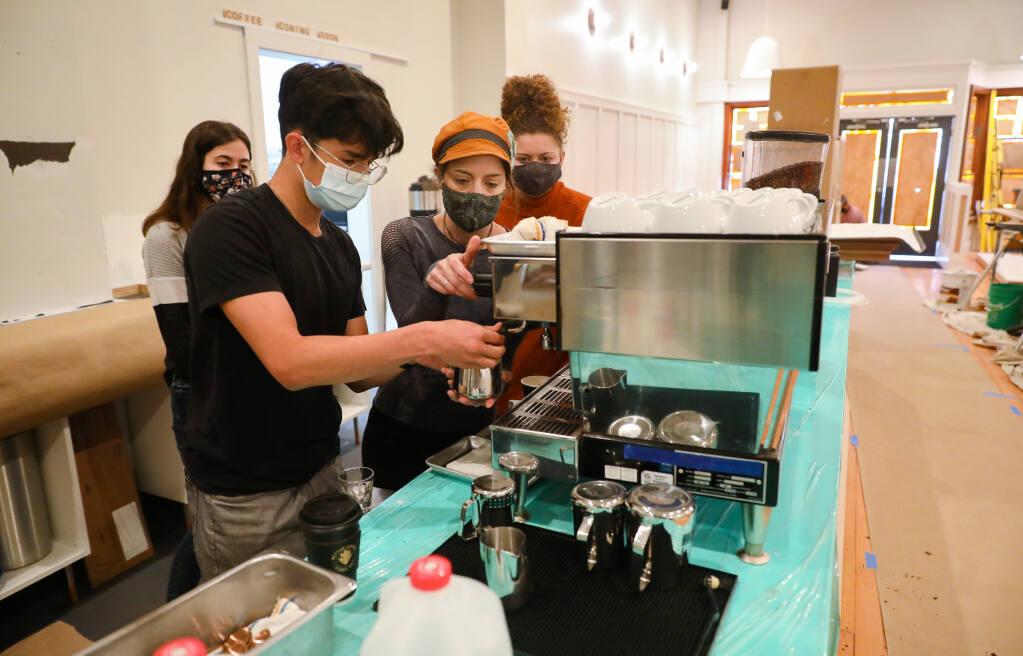 Lead barista Shelby Kobelin, second from right, shows trainee Alexander Limper how to operate the espresso machine at Black Oak Coffee Roasters, as trainees Jenna Burris, left, and Alex Shoop look on, in Healdsburg on Friday, April 9, 2021.  (Christopher Chung/ The Press Democrat)