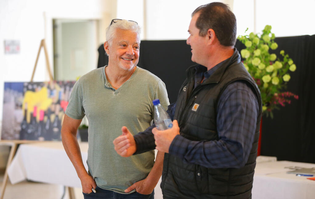 Daryl Groom, left, talks with George Christie during the North Coast Wine Challenge in Santa Rosa on Tuesday, April 5, 2022.  (Christopher Chung/ The Press Democrat)