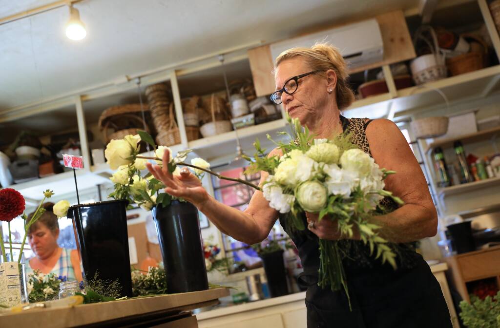 Pedy Lawson, owner of Pedy's Petals, puts together a bridal bouquet for an upcoming wedding elopement ceremony in Santa Rosa on Wednesday, July 1, 2020.  (Christopher Chung/The Press Democrat)