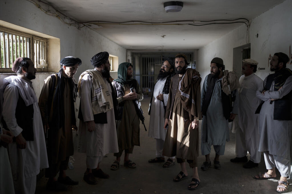 Taliban fighters, some former prisoners, chat in an empty area of the Pul-e-Charkhi prison in Kabul, Afghanistan, Monday, Sept. 13, 2021. Pul-e-Charkhi was previously the main government prison for holding captured Taliban and was long notorious for abuses, poor conditions and severe overcrowding with thousands of prisoners. Now after their takeover of the country, the Taliban control it and are getting it back up and running, current holding around 60 people, mainly drug addicts and accused criminals. (AP Photo/Felipe Dana)
