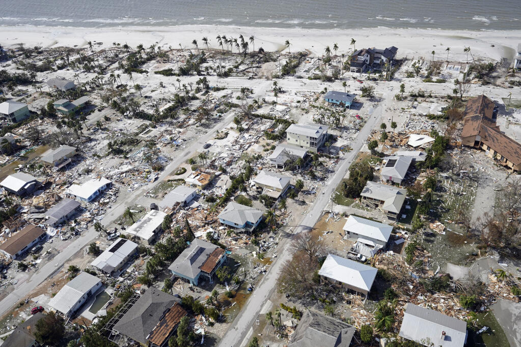 This aerial photo shows damaged homes and debris in the aftermath of Hurricane Ian, Thursday, Sept. 29, 2022, in Fort Myers Beach, Fla. (AP Photo/Wilfredo Lee)