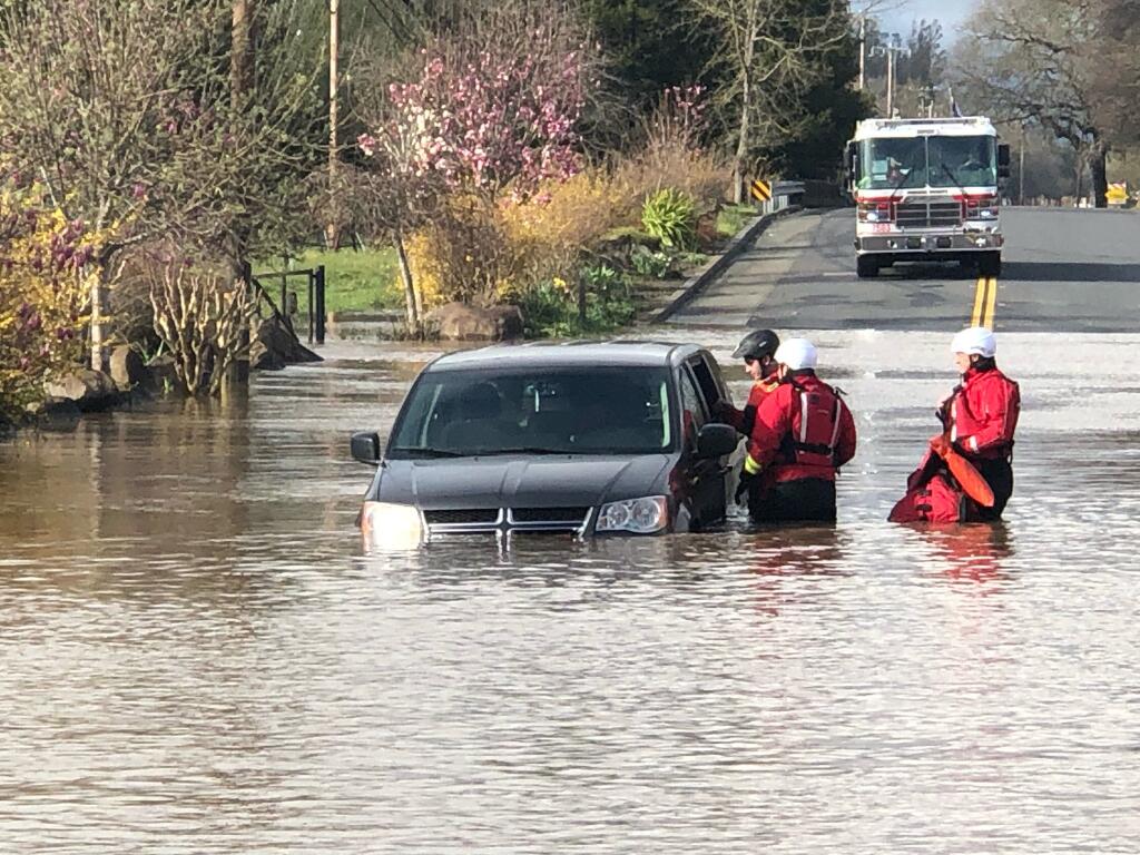 This image shows Sonoma County Fire District crews rescuing a driver trapped in flood waters on Slusser Road Tuesday, March 14, 2023. (Sonoma County Fire District)