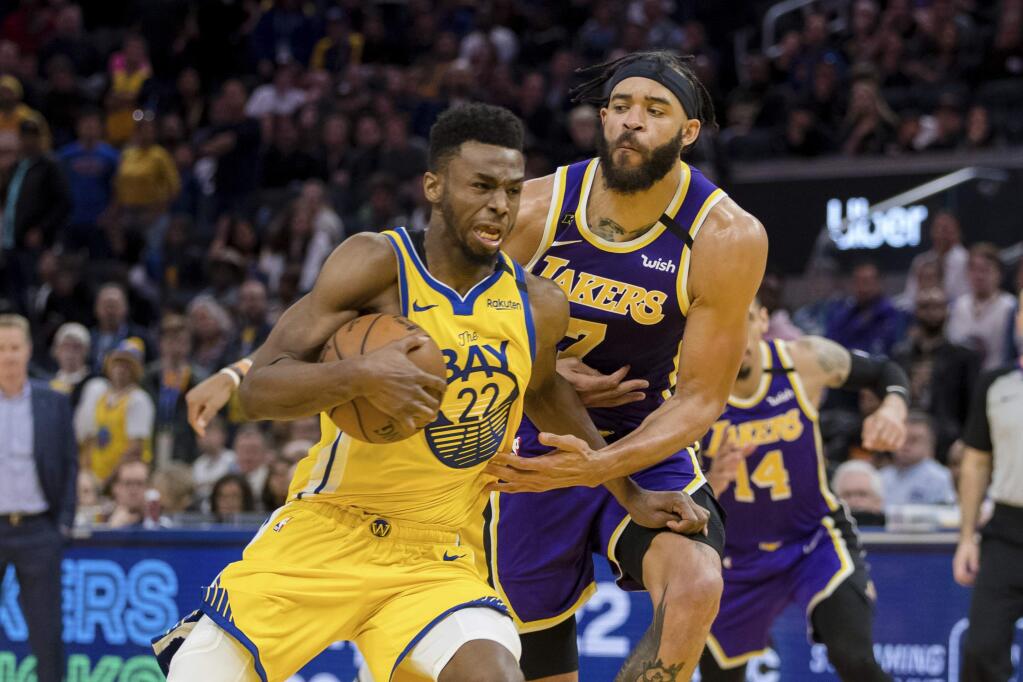 Golden State Warriors guard Andrew Wiggins (22) drives to the basket as Los Angeles Lakers center JaVale McGee, behind, defends in the second half of an NBA basketball game in San Francisco Saturday, Feb. 8, 2020. The Lakers won 125-120. (AP Photo/John Hefti)
