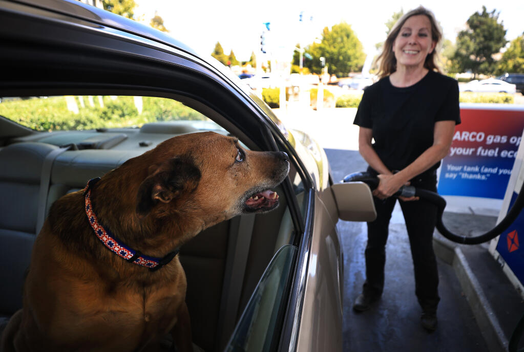 Jamuna Llewellyn of Forestville fills up with fuel at the Arco Station at Guerneville and Fulton Road's, Wednesday, July 6, 2022 as gas prices begin to decrease in the region. (Kent Porter / The Press Democrat) 2022