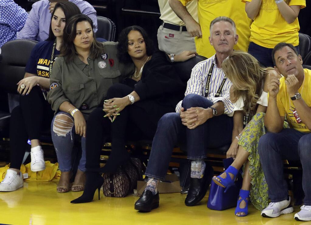 Singer Rihanna, second from left, watches Game 1 of basketball's NBA Finals between the Golden State Warriors and the Cleveland Cavaliers Thursday, June 1, 2017, in Oakland, Calif. (AP Photo/Marcio Jose Sanchez)