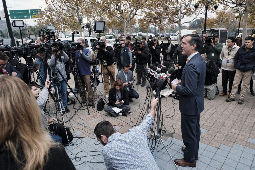 Los Angeles Mayor Eric Garcetti talks to the media before taking the subway to work from the Universal City Red Line station that has been threatened with attack in Los Angeles on Tuesday, Dec. 6, 2016. Heavily armed sheriff's deputies are guarding the station and other parts of Los Angeles County's transit system following a threat, which the FBI says specified the attack would occur Tuesday. (AP Photo/Richard Vogel)