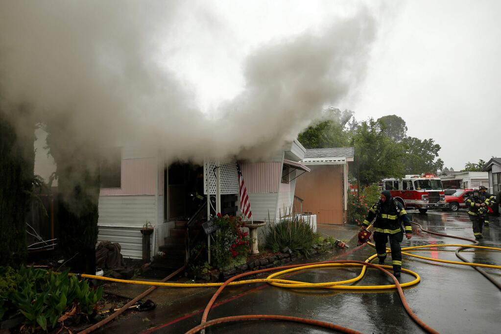 Sonoma County Fire District firefighters from Windsor and Rincon Valley respond to a house fire on Evergreen Avenue in Windsor, California, on Wednesday, May 15, 2019. (Alvin Jornada / The Press Democrat)