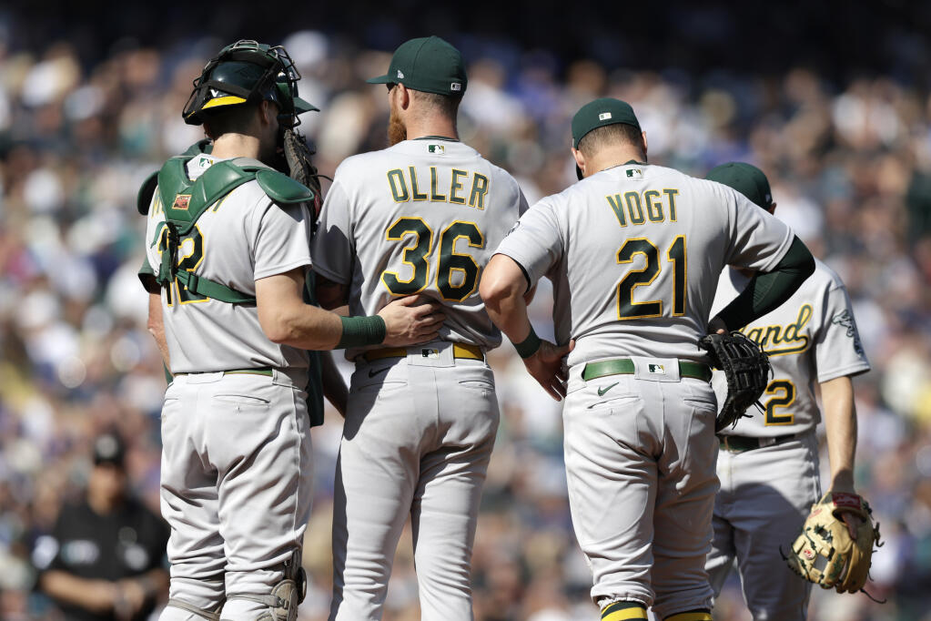 Oakland Athletics players surround starting pitcher Adam Oller (36) after he gave up a run during the first inning of a baseball game against the Seattle Mariners, Saturday, Oct. 1, 2022, in Seattle. (AP Photo/John Froschauer)