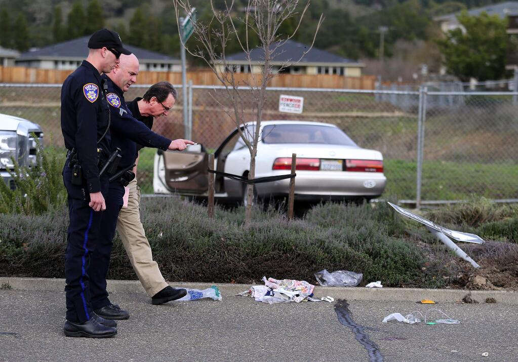 Santa Rosa police officers investigate the scene on Oakmont Dr. where two women pedestrians were struck by a 77-year-old woman who was arrested for suspected driving under the influence. Debris from the pedestrians littered the road and the white car ended up striking a fence after crossing four lanes. (JOHN BURGESS / The Press Democrat)