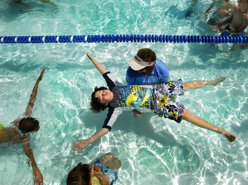 Brandon Watkins of Gravenstein School learns the basics of floating from volunteer Peggy Rogers during the Rotary Club's 25th year of sponsoring swimming lessons to west county second graders at Ives Pool in Sebastopol, Wednesday April 30, 2009. (Kent Porter / The Press Democrat file)