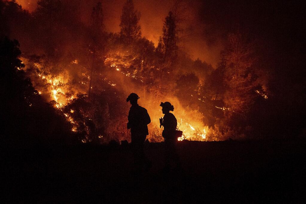 FILE - In this Aug. 7, 2018, file photo, firefighters monitor a backfire while battling the Ranch fire, part of the Mendocino Complex fires, near Ladoga, Calif. (AP Photo/Noah Berger, File)