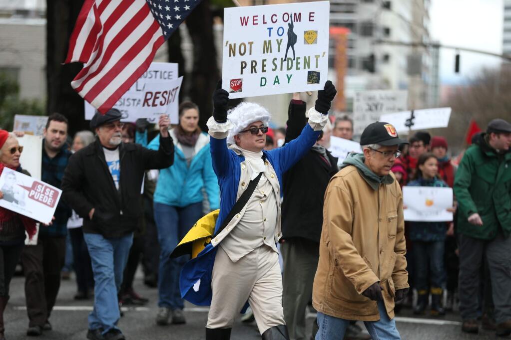 People participate in a protest Monday, Feb. 20, 2017, in Portland, Ore. Thousands of demonstrators turned out Monday across the U.S. to challenge President Donald Trump in a Presidents Day protest dubbed Not My President's Day. (Dave Killen/The Oregonian via AP)