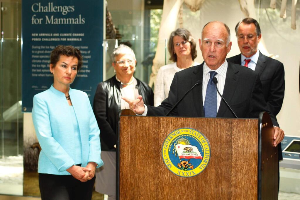 California Gov. Jerry Brown speaks at the podium as Christiana Figueres, far left, executive secretary of the United Nations Framework Convention on Climate Change, listens at a news conference at the natural History Museum of Los Angeles County in Los Angeles Monday, June 15, 2015. Brown says he wants California's plan to reduce greenhouse gas emissions to be a model when global leaders meet to try and fashion a universal agreement to combat climate change. Brown also met with Figueres and leading scientists to discuss the impacts of global warming and the need for action at all levels of government.(AP Photo/Matt Hartman)