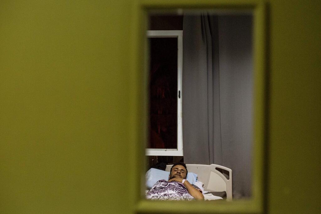An Egyptian man sleeps at Rashid Hospital in Rosetta, 65 kilometers (40 miles) northeast of Alexandria, Egypt, Thursday, Sept. 22, 2016 after being rescued from a boat which sank in the Mediterranean Sea. A boat carrying African migrants headed to Europe capsized off the Mediterranean coast off the coast of Alexandria on Wednesday, killing many people, Egyptian authorities said. Egypt's official news agency MENA said the boat was carrying 600 people when it sank. (AP Photo/Eman Helal)