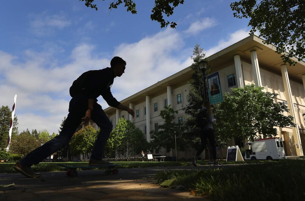 A student skates past Darwin Hall on the Sonoma State University campus, in Rohnert Park on Thursday, April 26, 2018. The university was one of four state colleges cited in a state auditor's resport for failing to adequately protect students and staff from hazardous materials used in labs and classrooms.(Christopher Chung/ The Press Democrat)