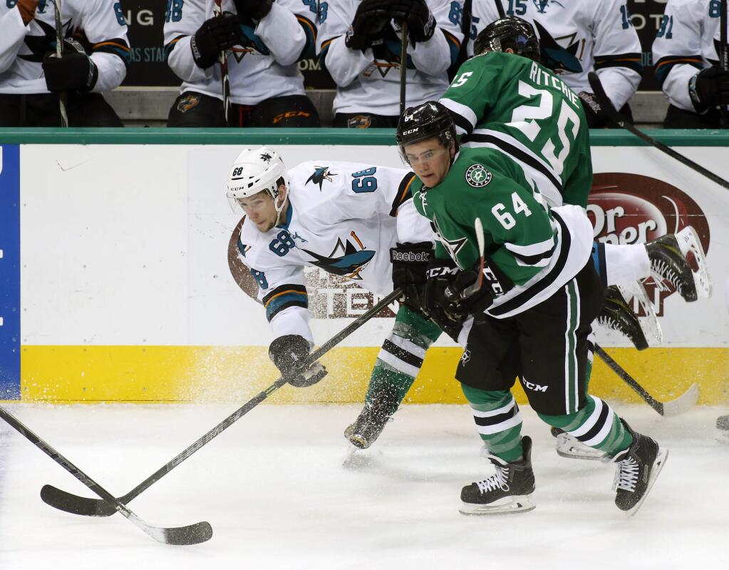 San Jose center Melker Karlsson (68) is knocked off his skates by Dallas Stars left wing Brendan Ranford (64) and right wing Brett Ritchie (25) during the third period of a game Thursday, Feb. 19, 2015, in Dallas. (AP Photo/Sharon Ellman)
