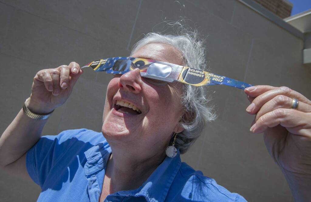 Children services librarian Clare O'Brien demonstrates a pair of the solar-eclipse-viewing glasses that were given away at the Sonoma Valley Regional Library in 2019 (Photo by Robbi Pengelly/Index-Tribune)