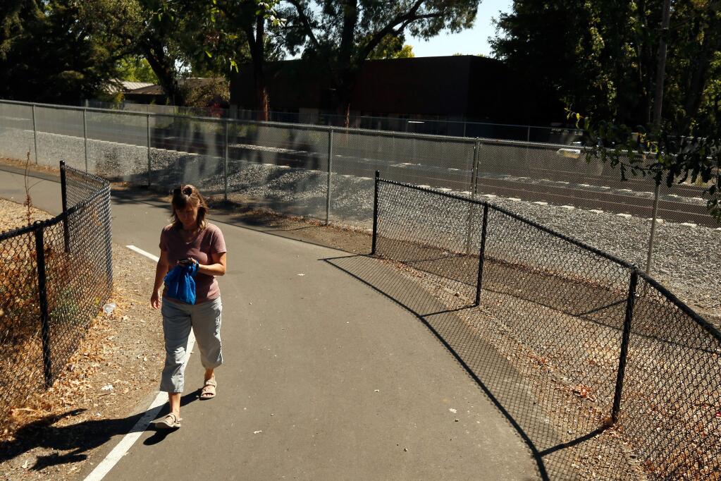 Kim Grindell of Santa Rosa walks along the SMART Trail on the east side of Jennings Avenue in Santa Rosa, California, on Friday, July 27, 2018. SMART informed Santa Rosa city officials that the transportation service no longer supports a pedestrian and bicycle crossing at Jennings Avenue, saying it may be too dangerous. (Alvin Jornada / The Press Democrat)