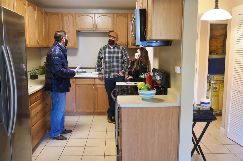 Realtor David Rendino, left, talks with Chris Palmer and Stephanie Reynolds as they conduct an inspection of the condominium they are in the process of buying in Santa Rosa on Monday, January 25, 2021.  (Christopher Chung/ The Press Democrat)