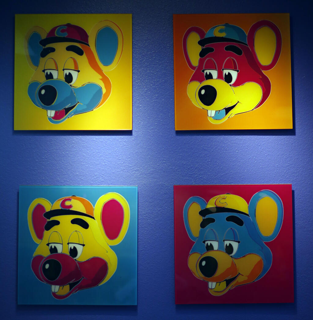 FILE - This Jan. 16, 2014 file photo shows paintings hanging  on a wall at Chuck E. Cheese's in Dallas. Chuck E. Cheese pizzeria, that Mecca of fun for children but the bane of many parents, is filing for bankruptcy protection. CEC Entertainment Inc. said Thursday, Jan. 25, 2020,  it was filing for voluntary protection under Chapter 11 “in order to overcome the financial strain resulting from prolonged, COVID-19 related venue closures.”  (G.J. McCarthy/The Dallas Morning News via AP)