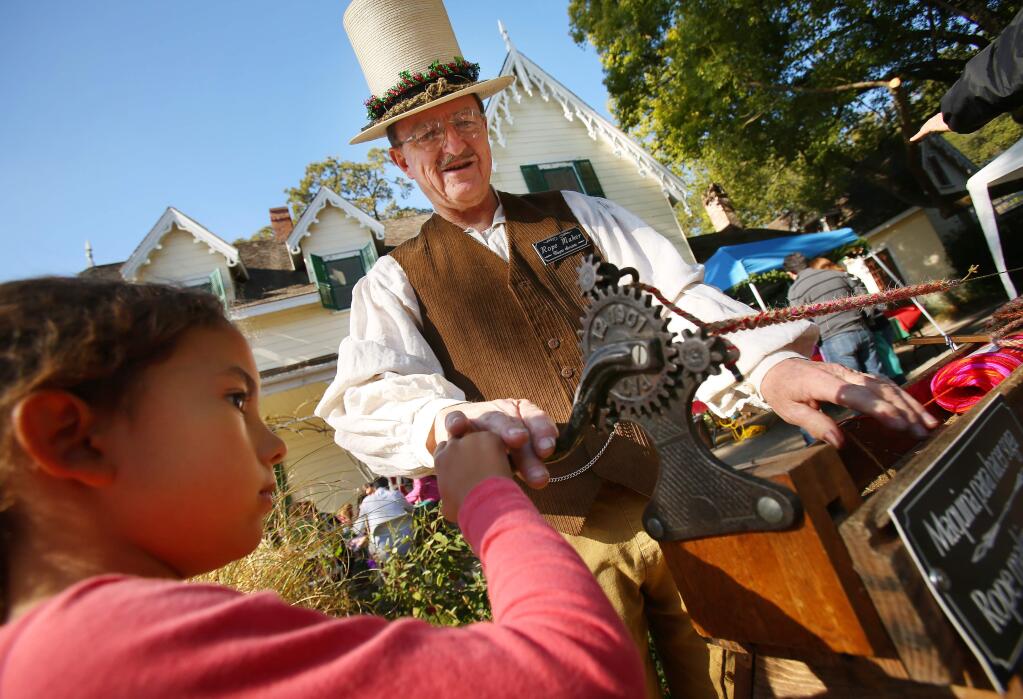 Wayne Sanders helps Mischa Brown twist her own piece of rope Sunday at the Victorian Christmas Crafts Workshop in Sonoma. File photo. (Conner Jay/The Press Democrat)