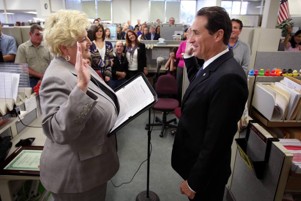 Bill Rousseau, right, is sworn in as Sonoma County's new clerk-recorder-assessor and elections chief by outgoing chief Janice Atkinson in Santa Rosa, on Monday, December 10, 2012. (Christopher Chung/ The Press Democrat)