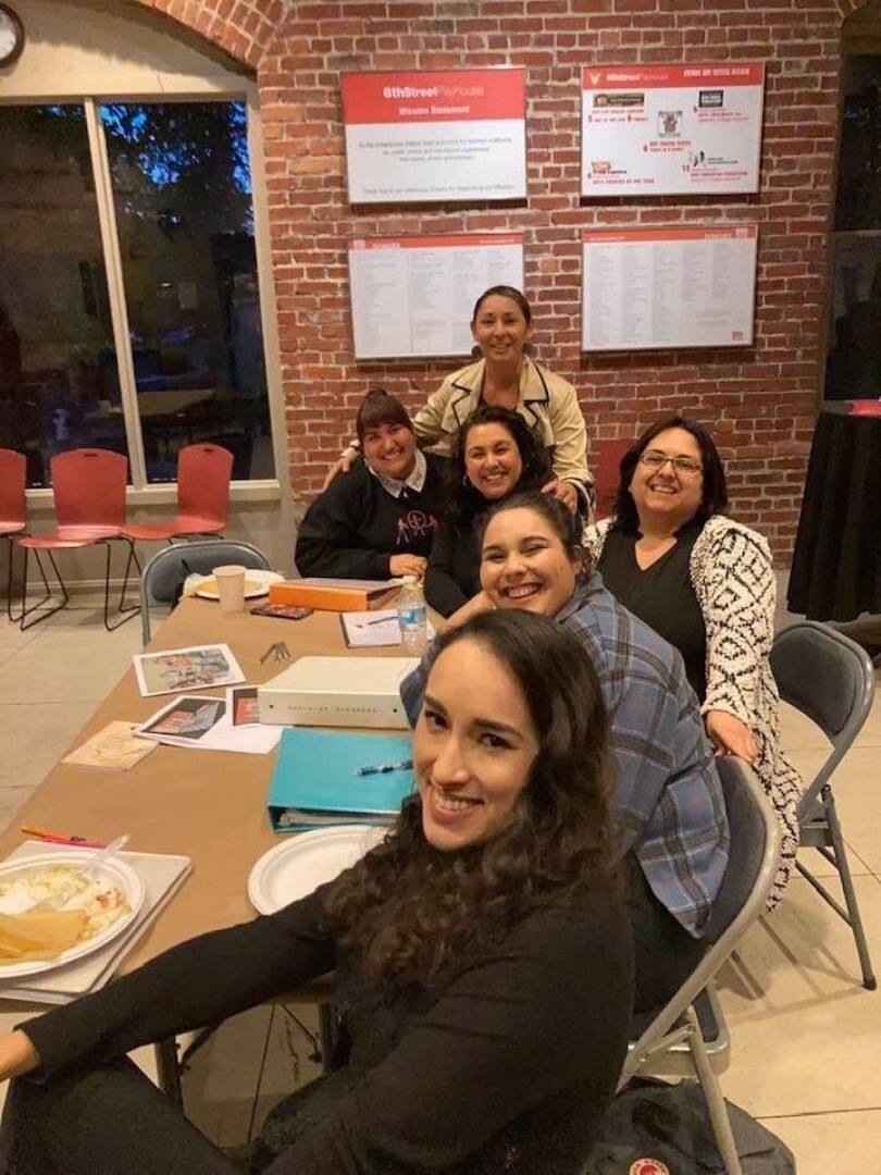 Marie Ramirez-Downing (standing) is the director of the 6th Street Playhouse production of “Real Women Have Curves.” The cast includes (sitting, from left top)  Alexa Jimenez, Anakarina Swanson, Rosa Reynoza, Reilly Milton and Bethany Regan. (6th Street Playhouse.)