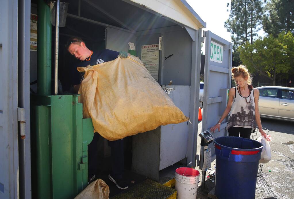 Joe Gali loads plastic bottles into a compactor while Betty Eppley waits for her receipt at the RePlanet recycling center in Rohnert Park, on Thursday, February 25, 2016. (Christopher Chung/ The Press Democrat)