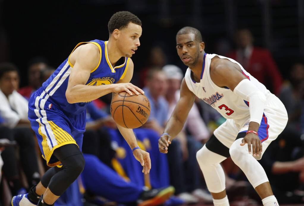 The Golden State Warriors' Stephen Curry, left, dribbles while the Los Angeles Clippers' Chris Paul, right, defends him during the first half Tuesday, March 31, 2015, in Los Angeles. (AP Photo/Danny Moloshok)