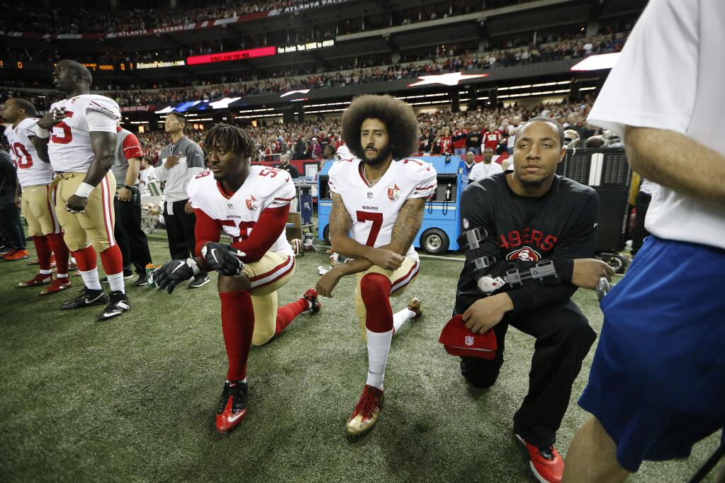 San Francisco 49ers quarterback Colin Kaepernick (7) and San Francisco 49ers outside linebacker Eli Harold (58) kneel during the playing of the National Anthem before the first half between the Atlanta Falcons and the 49ers, Sunday, Dec. 18, 2016, in Atlanta. (AP Photo/John Bazemore)