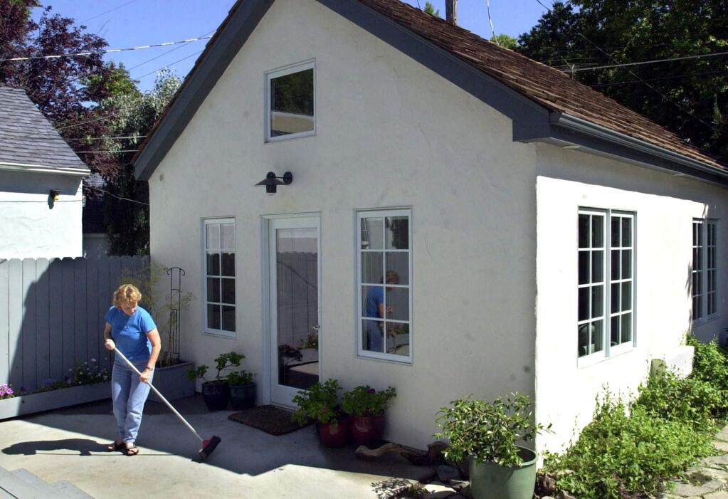 Christine Minnehan sweeps up in front of her 'granny flat' located in the backyard of her Sacramento home. (RICH PEDRONCELLI / Associated Press, 2002)